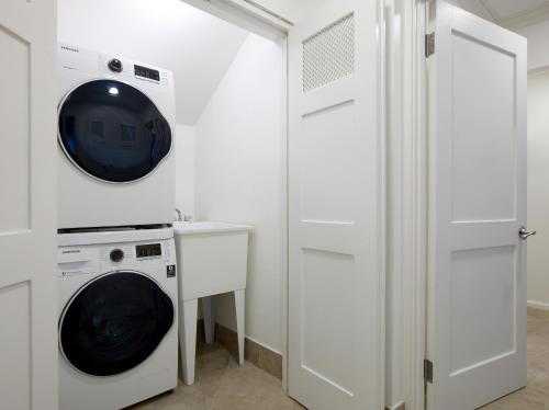 a white laundry room with a washer and dryer at Zenbreak KingsGate 1 in Saint Peter