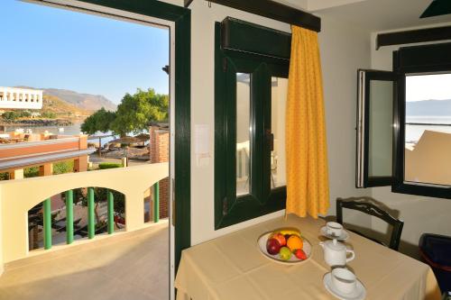 a table with a bowl of fruit next to a window at Maria Beach Hotel in Kissamos