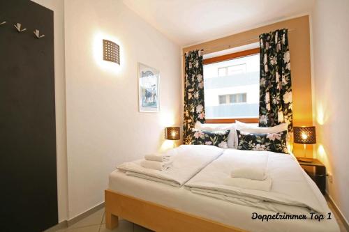 a bedroom with a large bed with a window at Almliesl ZELL-232 in Zell am See