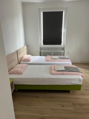 two twin beds in a room with a window at Waffel Cafe HOSTEL Monteurwohnung Ferienwohnung in Kassel