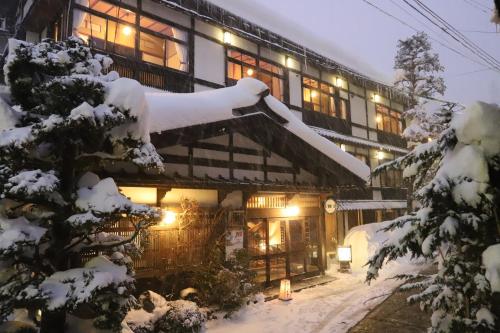 a building covered in snow at night at 野沢温泉 奈良屋旅館 in Nozawa Onsen