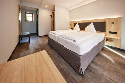 a bedroom with a large bed and a chair at Zum Roten Bären in Freiburg im Breisgau