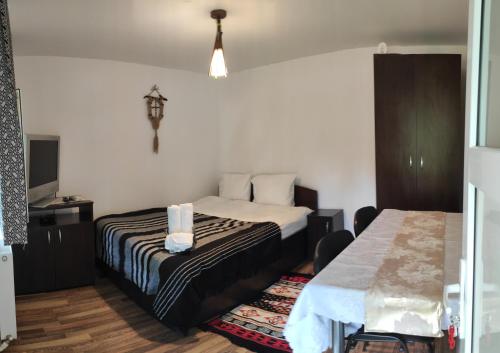 a hotel room with a bed and a tv at Pensiunea Poiana Marului - Bisoca in Bisoca