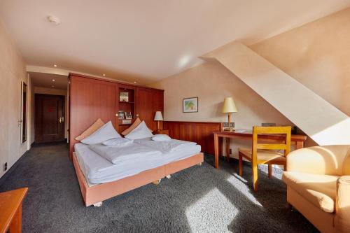 a bedroom with a bed and a desk and a chair at Zum Roten Bären in Freiburg im Breisgau