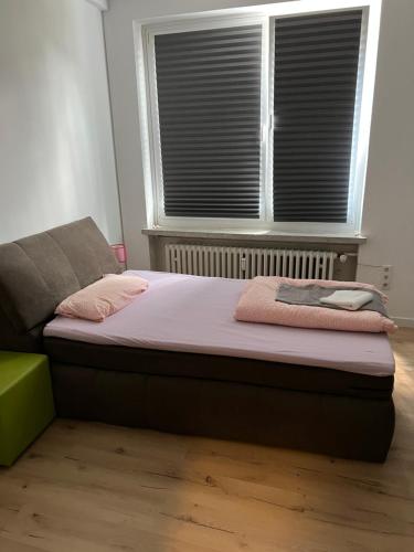 a bed sitting in a room with a window at Waffel Cafe HOSTEL Monteurwohnung Ferienwohnung in Kassel