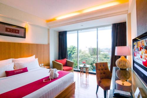 a hotel room with a bed and a large window at Emersia Hotel and Resort in Bandar Lampung