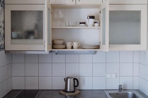 a kitchen with white cabinets and a sink at Moon Garden Old Town Hotel in Vilnius