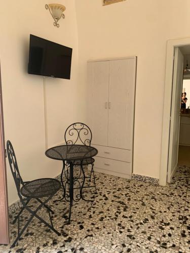 a room with a table and two chairs and a television at Nonna Veronica in Gemini