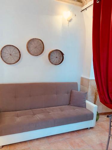 a couch against a white wall with three circles on it at Nonna Veronica in Gemini