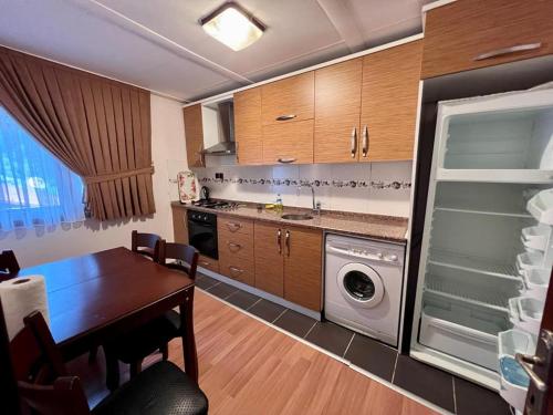 a kitchen with a table and a washer and dryer at Kibar Home in Uzungol