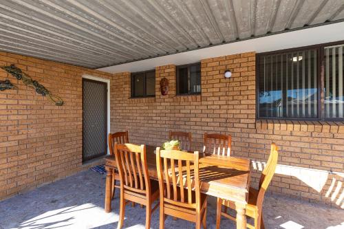 a wooden table and chairs on a patio at Flora Parade 6 in Tuncurry