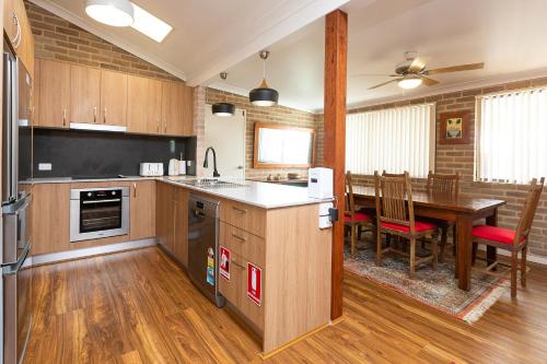 a kitchen with a table and a dining room at Flora Parade 6 in Tuncurry