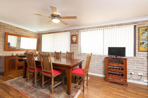 a dining room with a table and a tv at Flora Parade 6 in Tuncurry
