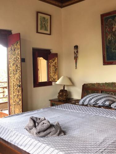 a bedroom with a bed with a towel on it at Nirvana Pension in Ubud