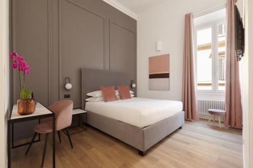 a bedroom with a bed and a table and a desk at DA ME Suites in Rome