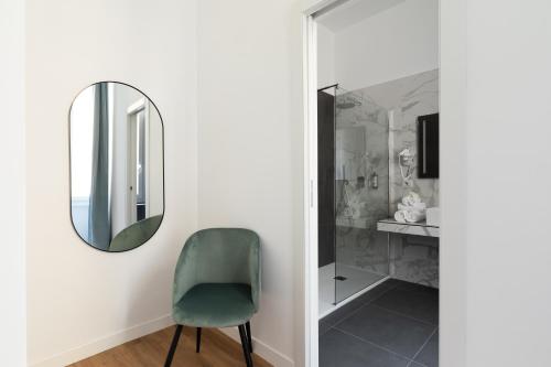 a mirror and a green chair in a room at DA ME Suites in Rome