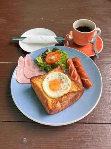 a plate of food with eggs and toast and a cup of coffee at Srikij GardenHome Resort in Sa Kaeo