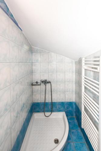 a bath tub in a bathroom with blue and white tiles at Olive Garden Vila in Exopoli
