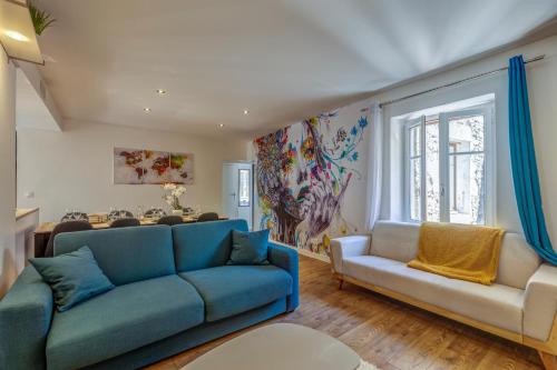 ein Wohnzimmer mit einem blauen Sofa und einem Tisch in der Unterkunft Le Paquier - MyCosyApart, Vieille ville, Calme, Lac 100m, Netflix in Annecy