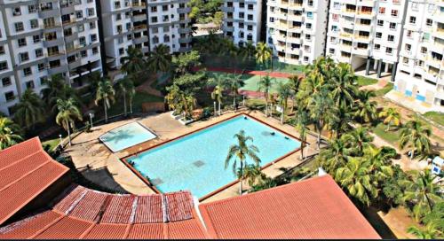- une vue sur la piscine bordée de palmiers et de bâtiments dans l'établissement 7 Sea Pd Marina Apartment, à Port Dickson