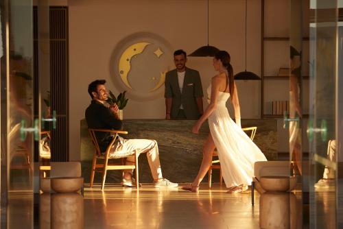 a woman in a white dress walking next to a man at Asterion Suites & Spa - Designed for Adults in Gerani