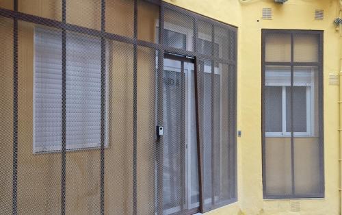 una ventana con persianas en el lateral de un edificio en APARTAMENTOS DESAMPARADOS, en Murcia