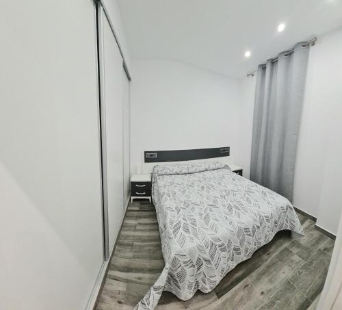 1 dormitorio con cama y espejo grande en APARTAMENTOS DESAMPARADOS, en Murcia