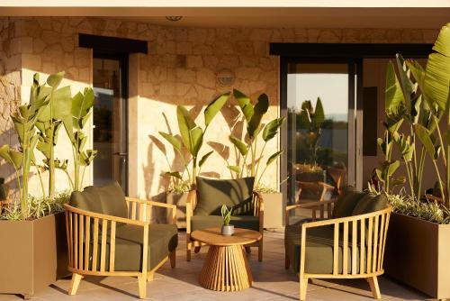 a patio with chairs and a table and plants at Asterion Suites & Spa - Designed for Adults in Gerani Chanion