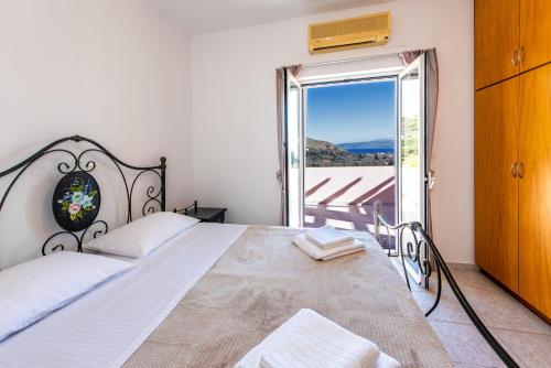 Schlafzimmer mit einem Bett und einer Tür zu einem Balkon in der Unterkunft Olive Garden Vila in Exopoli