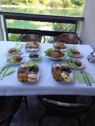 a table with many plates of food on it at Prenoćište na Drini Foča in Foča
