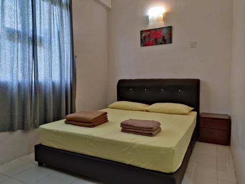 um quarto com uma cama com duas toalhas em Penang Tanjung Bungah Medium Cost Apartment Stay em Tanjung Bungah