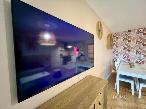 a large flat screen tv on a wall in a room at 123home- Garden & Spa in Serris