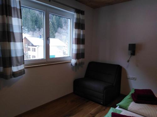 a living room with a chair and a window at Alpenchalet Breitspitz in Partenen