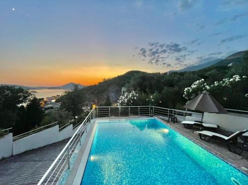 a swimming pool on top of a building with a sunset at Seaview Couple Studio with pool-Przno in Pržno