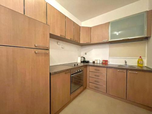 a kitchen with wooden cabinets and stainless steel appliances at Seaview Couple Studio with pool-Przno in Pržno