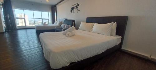 ein Schlafzimmer mit einem großen Bett mit einer weißen Bettdecke in der Unterkunft SY Staycation - Apartment with Netflix in Bayan Lepas