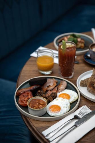 a table with a breakfast plate of eggs and mushrooms at The Windmill On The Common in London