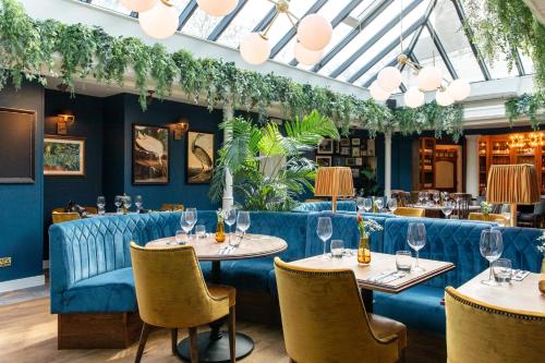 a restaurant with two tables and chairs with wine glasses at The Windmill On The Common in London
