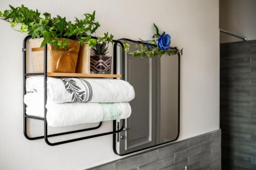 un toallero con toallas y plantas en un espejo en Villa Ribella - Family Apartment, en San Damiano dʼAsti