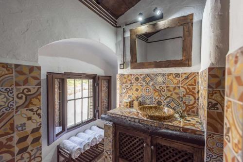 a bathroom with a sink and a mirror at Casa Rural San Miguel in Morón de la Frontera