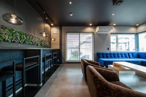 a restaurant with a blue couch and a table and chairs at THE BEEHIVE AIOI in Otaru