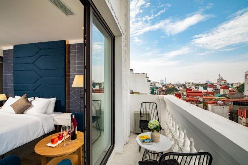 a bedroom with a bed and a view of a city at HÔTEL De SOURIANT Central Hanoi in Hanoi