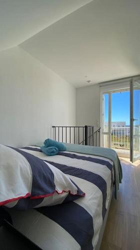 un lit dans une chambre avec une grande fenêtre dans l'établissement Studio duplex face à la mer, à Guidel