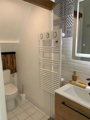 une salle de bain blanche avec des toilettes et un lavabo dans l'établissement Studio duplex face à la mer, à Guidel