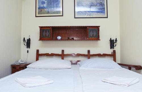 two beds in a bedroom with two white pillows at Kalmár Panzió in Budapest