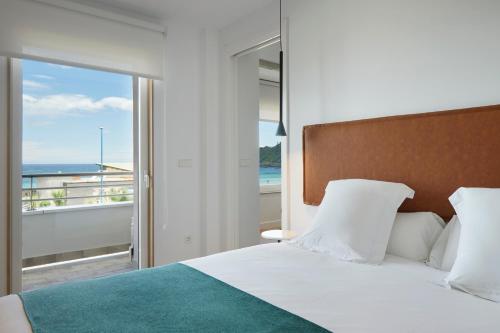 um quarto com uma cama e vista para o oceano em Zinemaldi Suite by FeelFree Rentals em San Sebastián