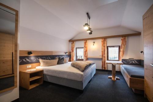 a bedroom with a large bed and a couch at Landhaus Gasser in Wenns