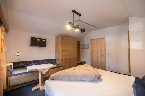 a bedroom with a bed and a tv on the wall at Landhaus Gasser in Wenns