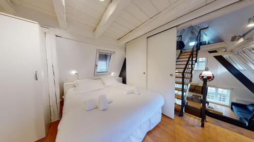 Un dormitorio con una gran cama blanca y una escalera en Le Lohkäs - LOFT Triplex Ultra Design Petite France, en Estrasburgo