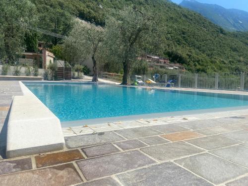 een groot zwembad met een berg op de achtergrond bij Residence Kormorano in Malcesine